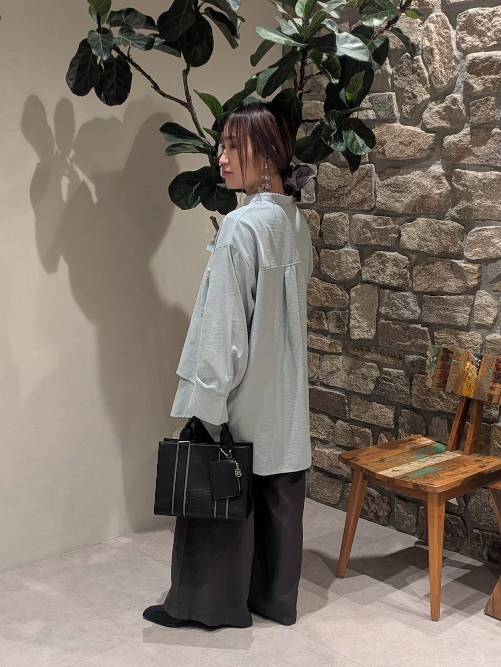 ブラック系のブーツ、ブルー系のシャツ/ブラウス、ブラック系のハンドバッグを着用したレディースの冬コーディネートの2枚目の写真