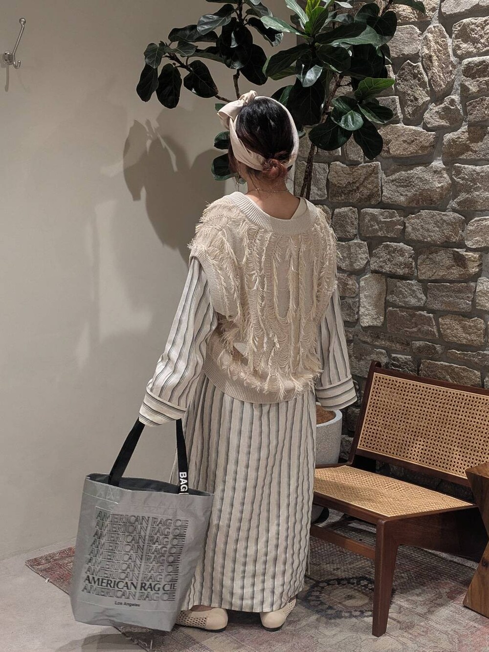 ベージュ系のパンプス、ベージュ系のベスト、シルバー系のトートバッグを着用したレディースの春コーディネートの2枚目の写真