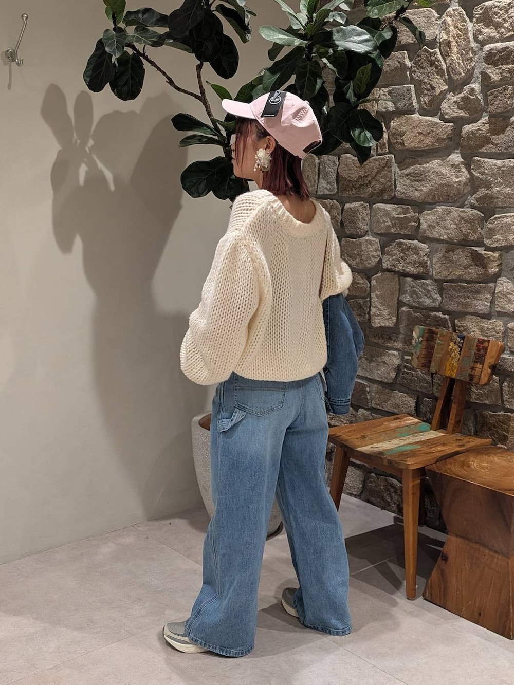 グレー系のスニーカー、ブラウン系のショルダーバッグ、ブルー系のデニムパンツを着用したレディースの冬コーディネートの2枚目の写真