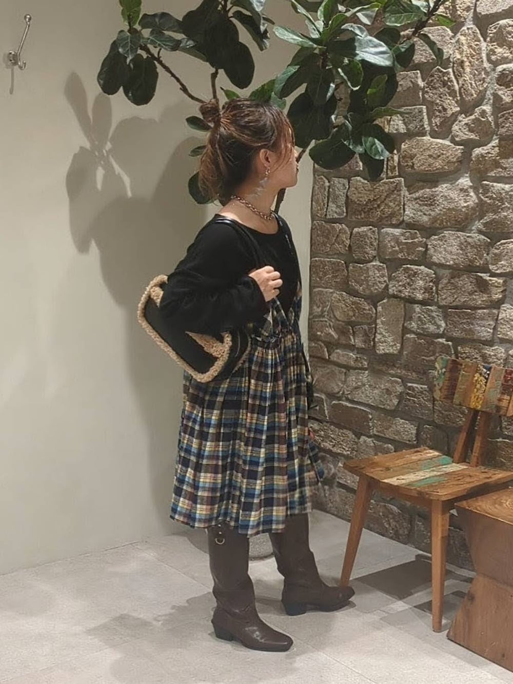 ブラウン系のブーツ、ブラック系のハンドバッグ、グレー系のネックレスを着用したレディースの秋コーディネートの2枚目の写真