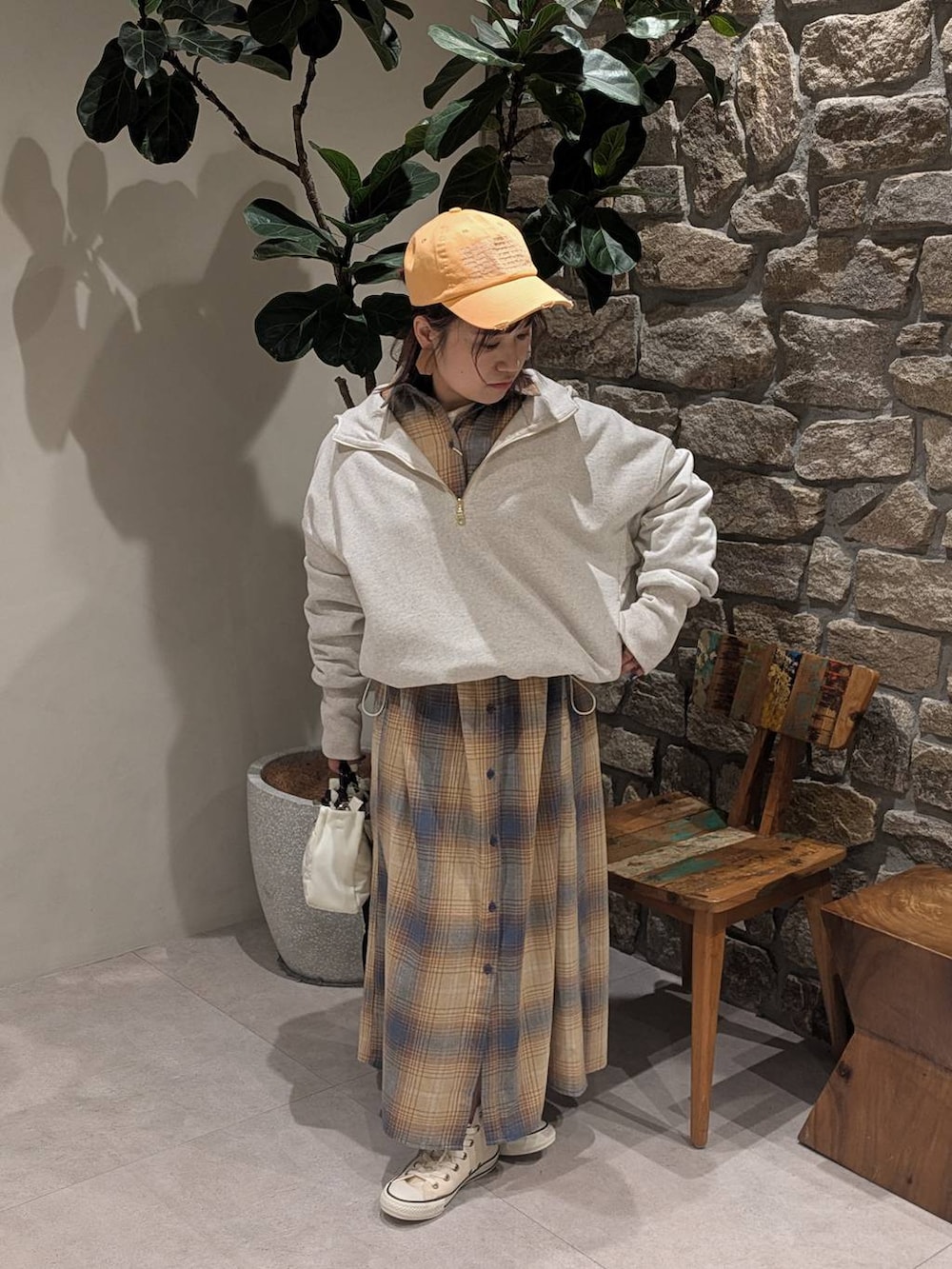 ホワイト系のスニーカー、イエロー系のシャツワンピース、ホワイト系のショルダーバッグを着用したレディースの冬コーディネートの2枚目の写真