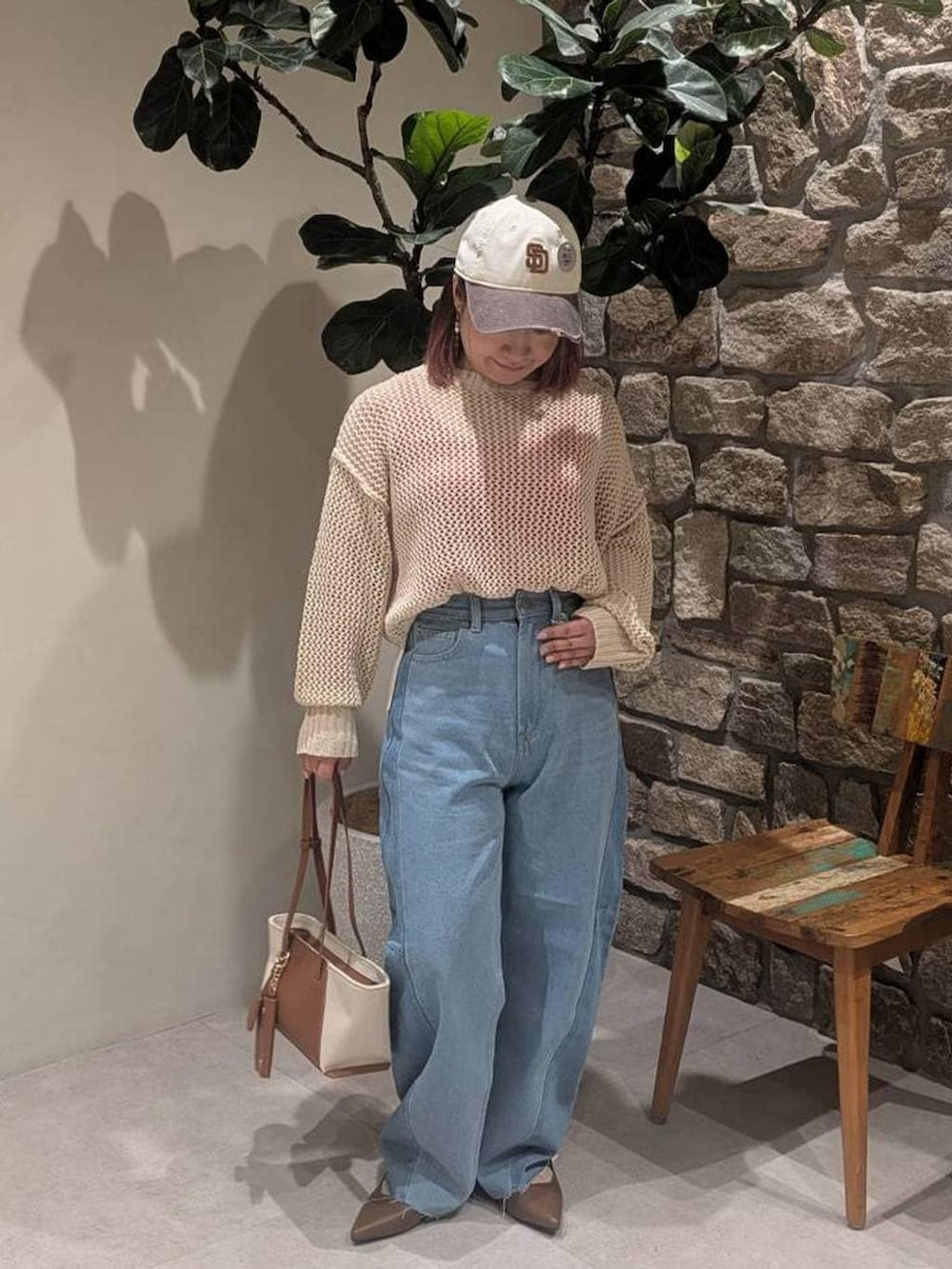 レッド系のタンクトップ、ブラウン系のハンドバッグ、ブラウン系のパンプスを着用したレディースの春コーディネートの3枚目の写真