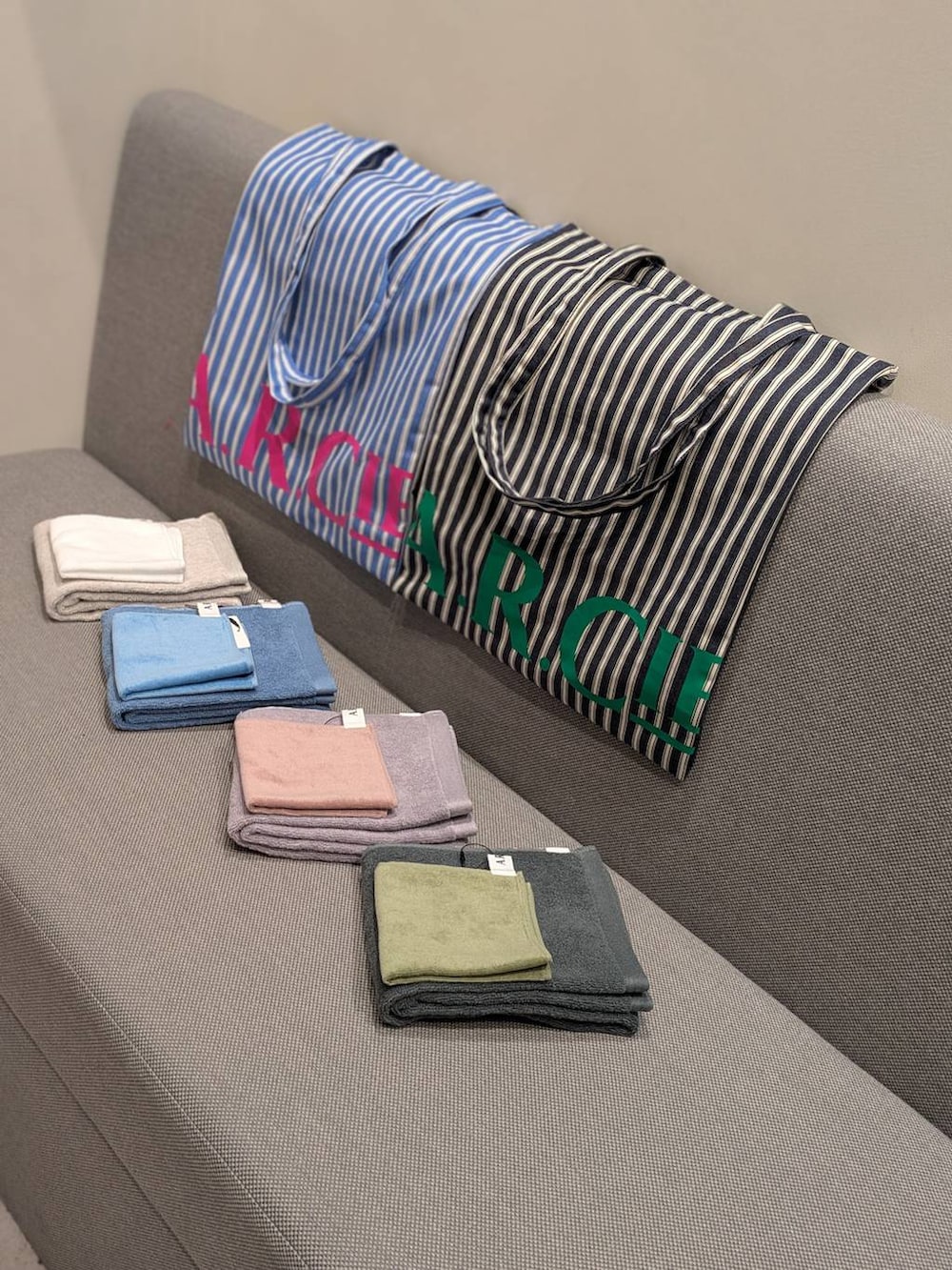 ホワイト系のパーカー、ブルー系のトートバッグ、グレー系のトートバッグを着用したレディースの春コーディネートの2枚目の写真