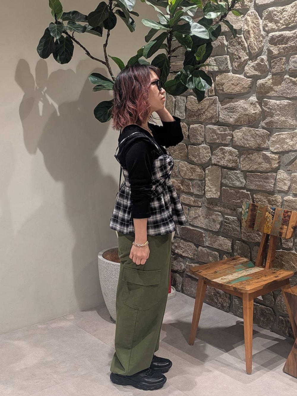 ブラック系のスニーカー、ブラック系のキャミソール、ホワイト系のショルダーバッグを着用したレディースの冬コーディネートの2枚目の写真