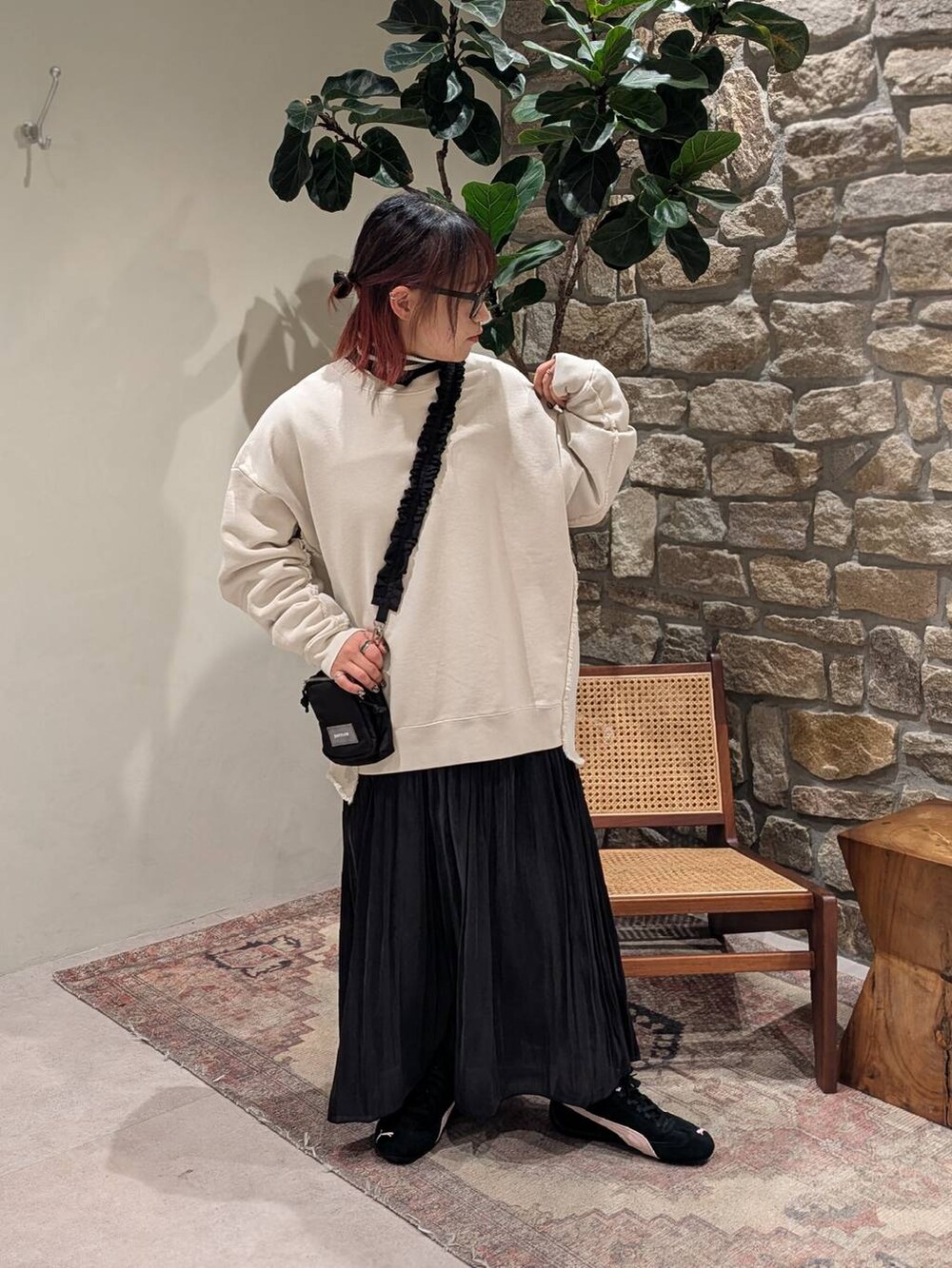 ブラック系のニット/セーター、ブラック系のショルダーバッグ、ブラック系のスカートを着用したレディースの冬コーディネートの2枚目の写真