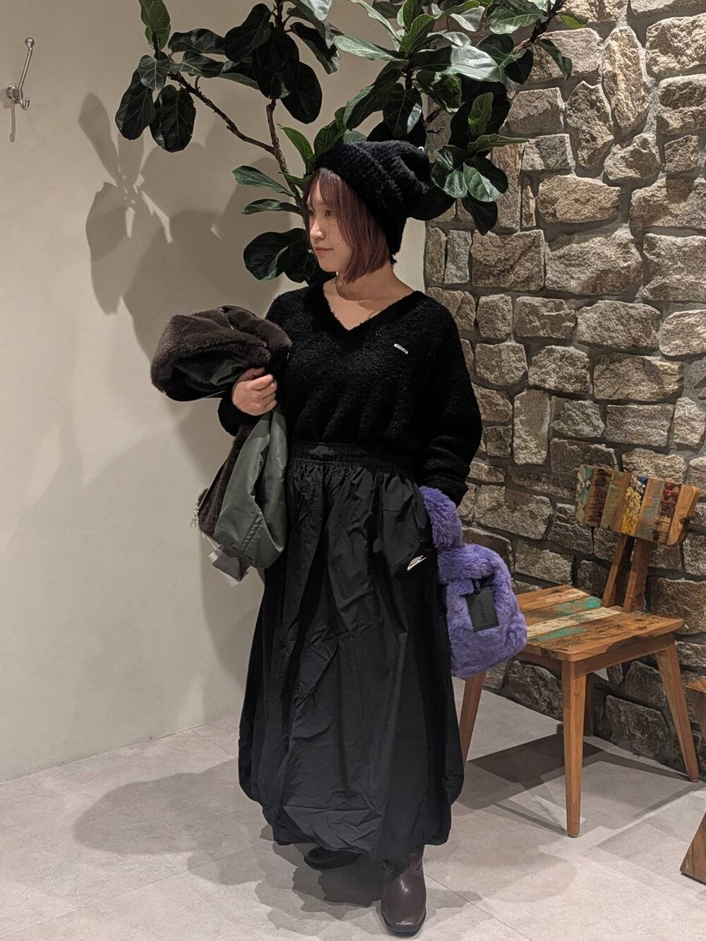 ブラウン系のブーツ、ブラウン系のブルゾン、パープル系のハンドバッグを着用したレディースの秋コーディネートの3枚目の写真