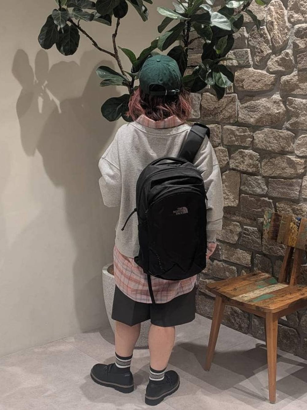 オレンジ系のシャツ/ブラウス、ブラック系のバックパック/リュック、ブラック系のローファーを着用したレディースの冬コーディネートの3枚目の写真