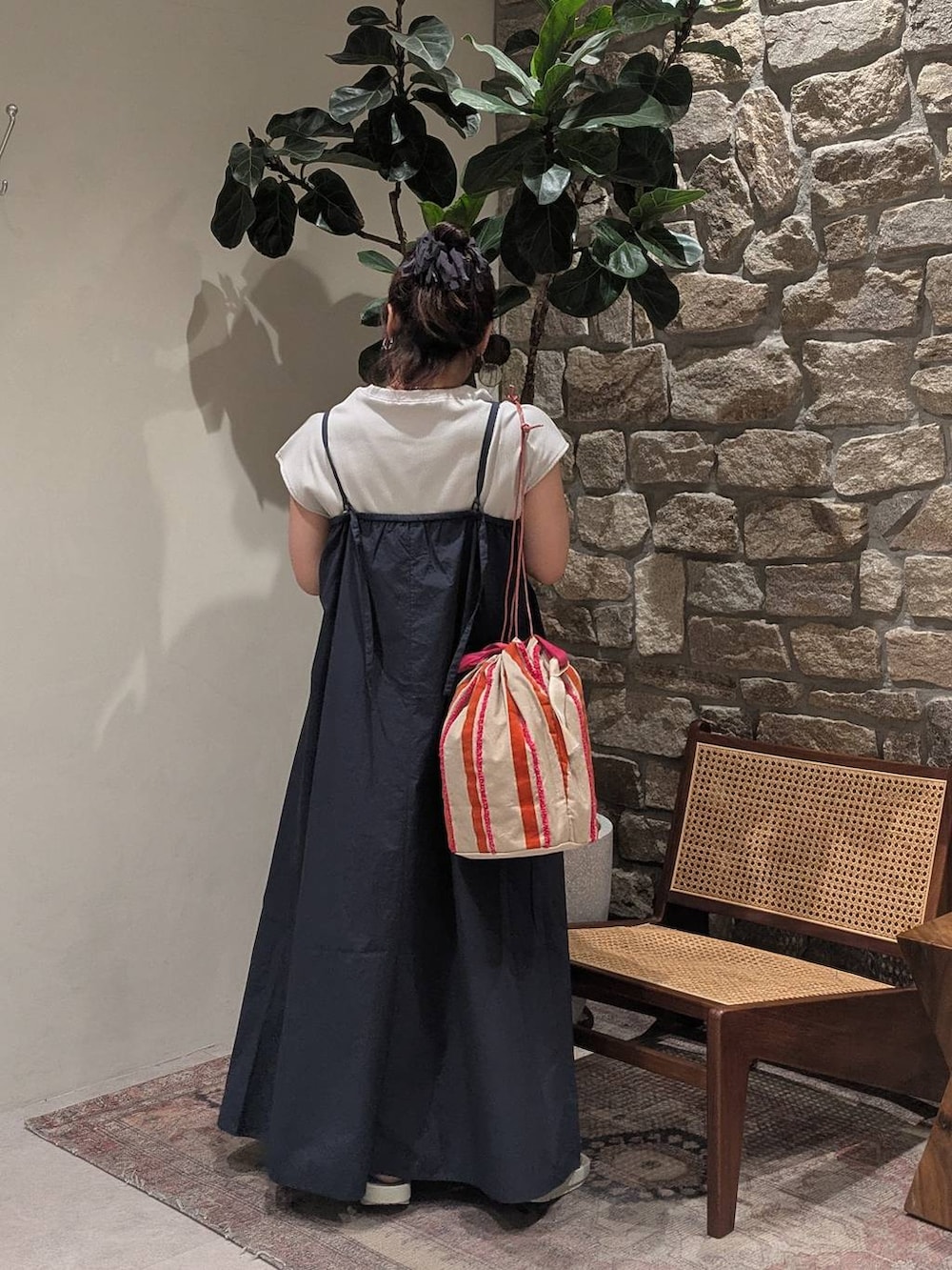 ピンク系のハンドバッグ、グレー系のサンダル、ブルー系のジャンパースカートを着用したレディースの春コーディネートの3枚目の写真