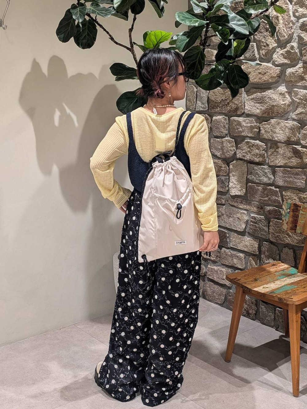 ホワイト系のスニーカー、ホワイト系のバックパック/リュック、ブラック系のその他パンツを着用したレディースの春コーディネートの3枚目の写真