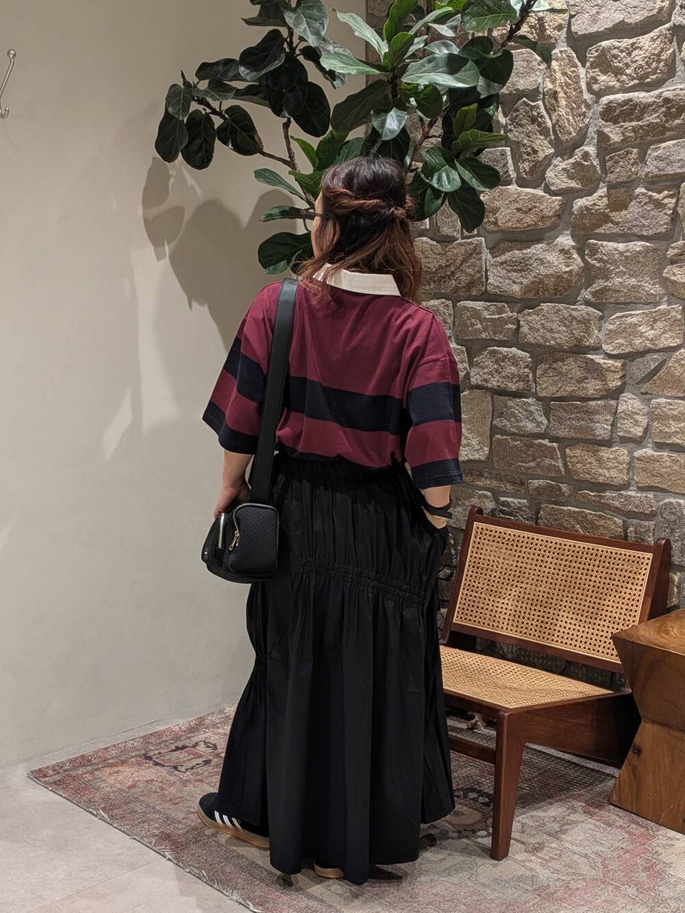 ブラック系のスニーカー、ブラック系のショルダーバッグ、ブルー系のその他トップスを着用したレディースの夏コーディネートの3枚目の写真