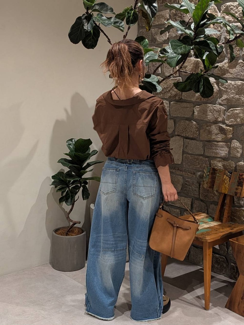 ブルー系のデニムパンツ、ブラウン系のサンダル、イエロー系のショルダーバッグを着用したレディースの夏コーディネートの4枚目の写真