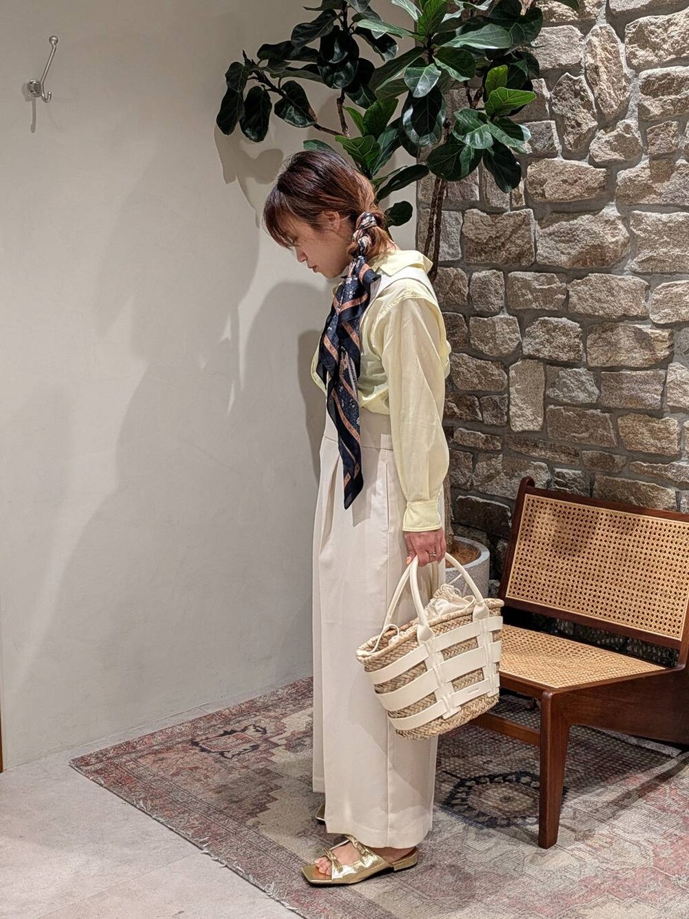 ゴールド系のサンダル、ホワイト系のかごバッグ、イエロー系のシャツ/ブラウスを着用したレディースの春コーディネートの3枚目の写真