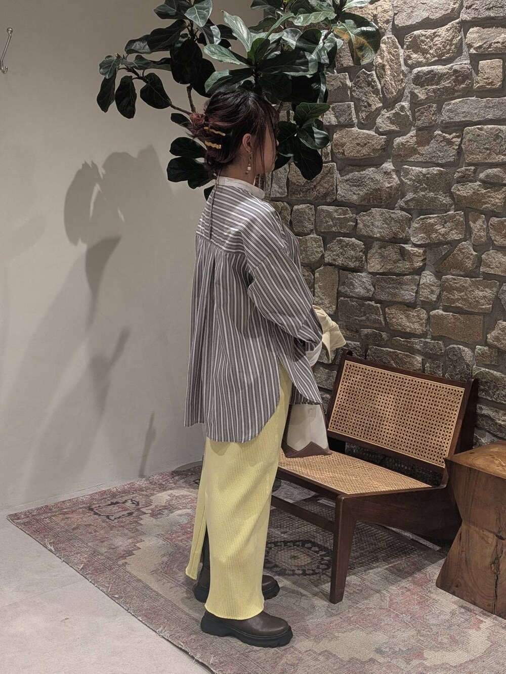 ブラウン系のブーツ、ベージュ系のトレンチコート、ブラウン系のトートバッグを着用したレディースの冬コーディネートの5枚目の写真