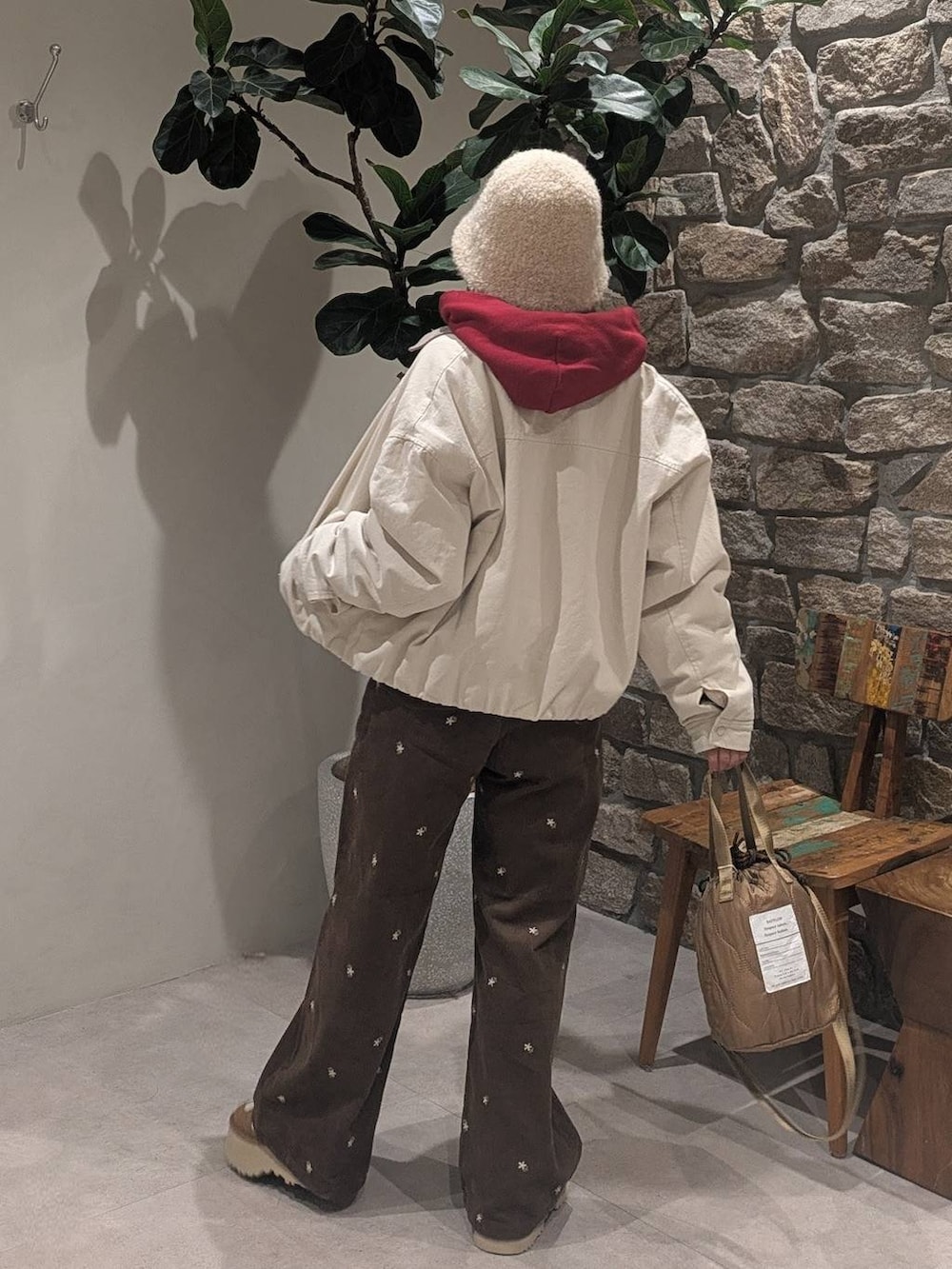 ブラウン系のその他パンツ、レッド系のパーカー、ベージュ系のショルダーバッグを着用したレディースの冬コーディネートの2枚目の写真