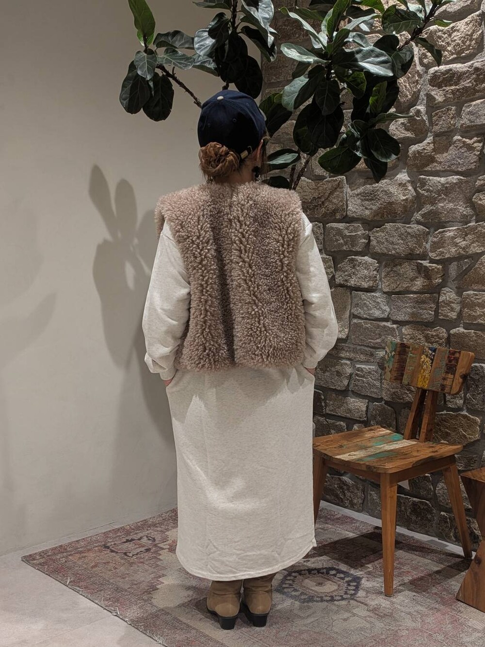 ベージュ系のブーツ、ブラウン系のベスト、ホワイト系のトートバッグを着用したレディースの秋コーディネートの3枚目の写真