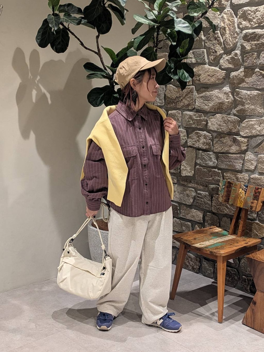 ブルー系のスニーカー、ブラウン系のシャツ/ブラウス、ホワイト系のショルダーバッグを着用したレディースの冬コーディネートの2枚目の写真