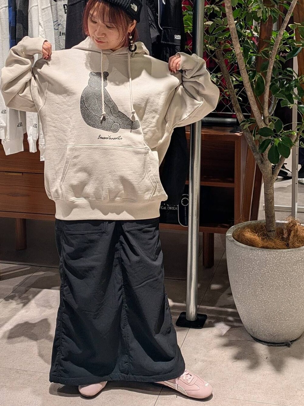 ピンク系のスニーカー、ブラック系のスカート、グレー系のパーカーを着用したレディースの秋コーディネートの2枚目の写真