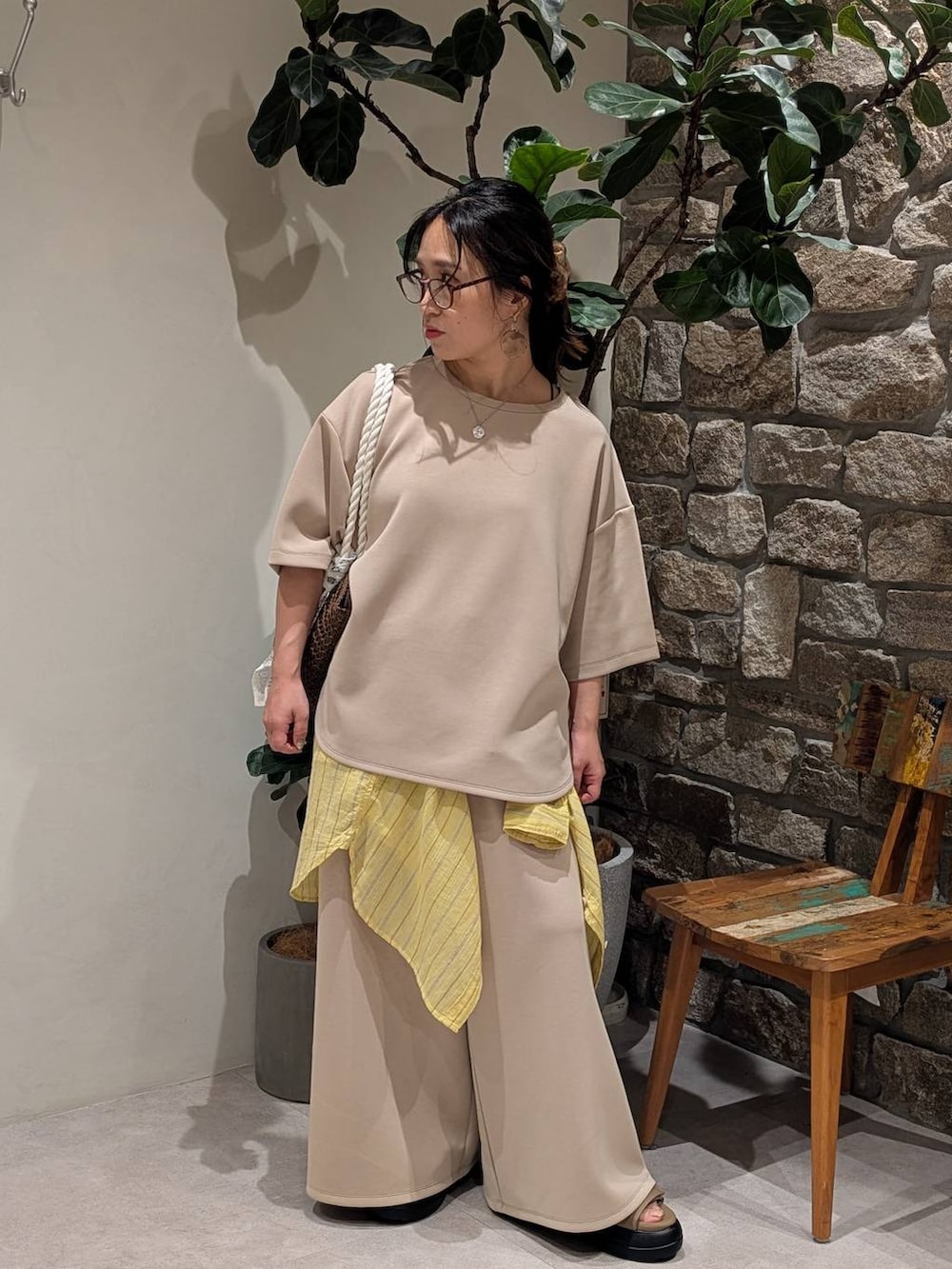 イエロー系のシャツ/ブラウス、ブラウン系のトートバッグ、ブラウン系のサンダルを着用したレディースの夏コーディネートの2枚目の写真