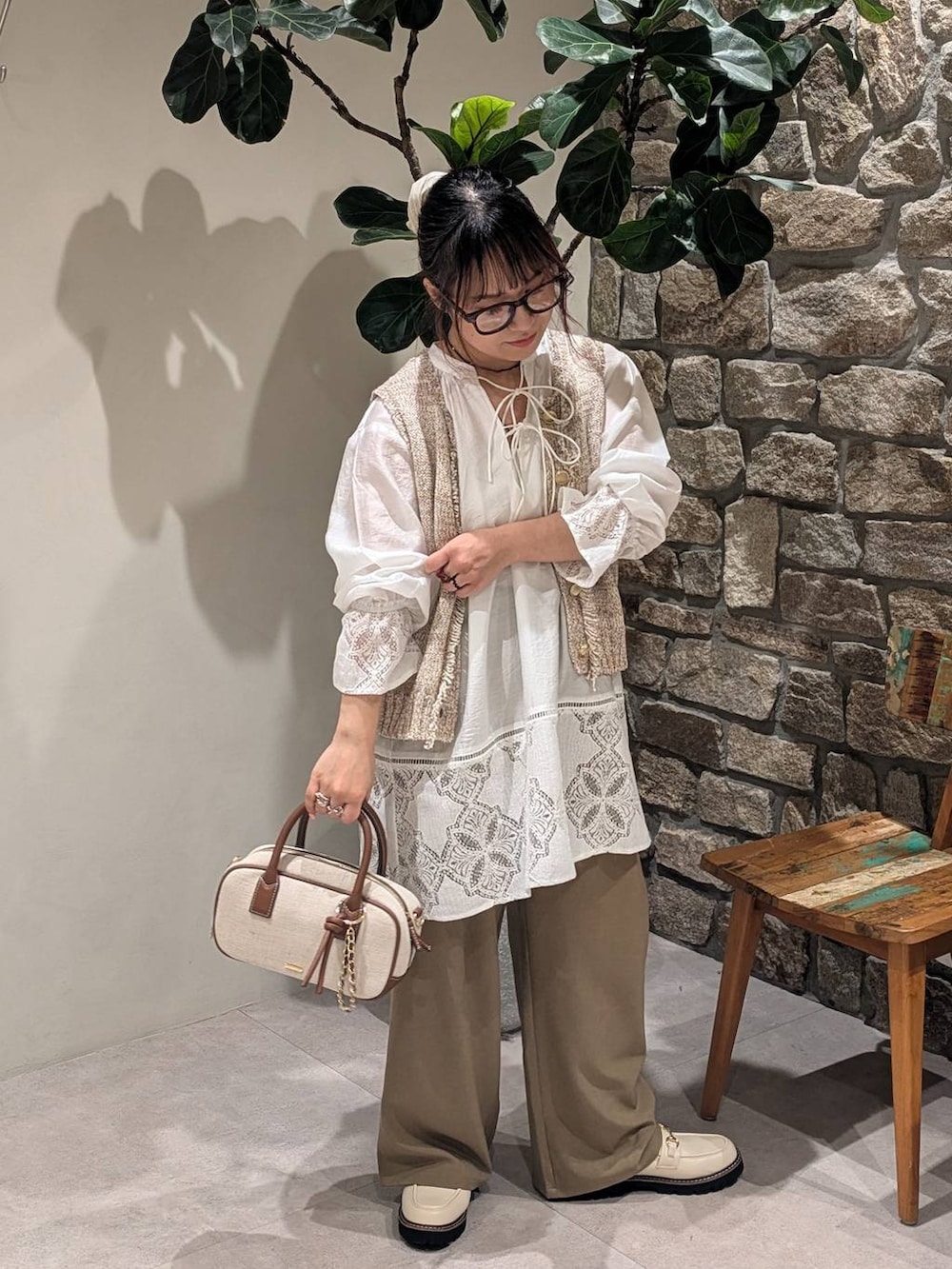 ホワイト系のローファー、ベージュ系のハンドバッグ、ブラウン系のその他パンツを着用したレディースの春コーディネートの2枚目の写真