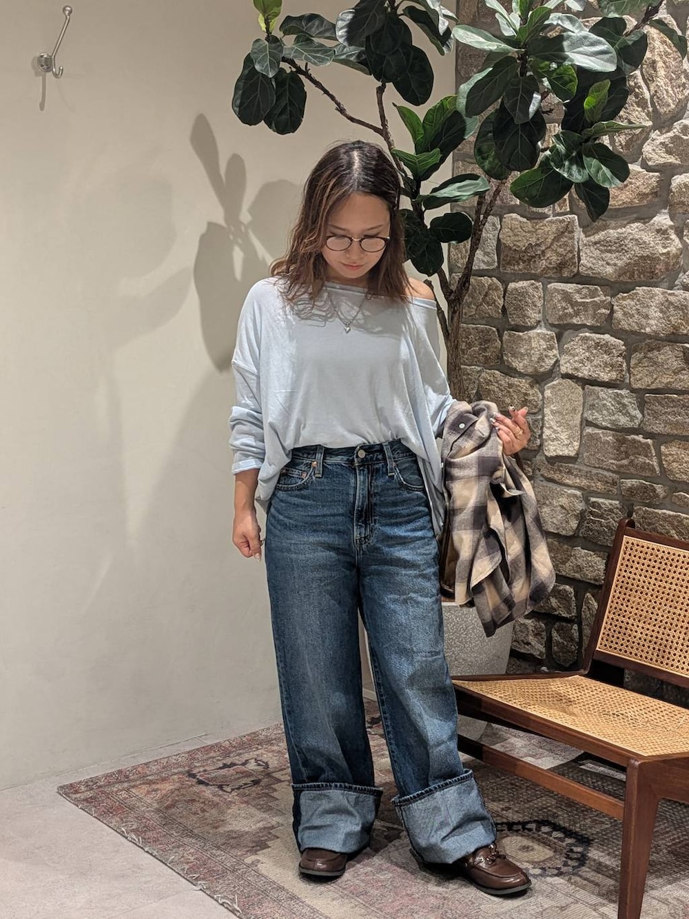 ブルー系のデニムパンツ、ベージュ系のシャツ/ブラウス、ブラウン系のモカシン/デッキシューズを着用したレディースの夏コーディネートの3枚目の写真