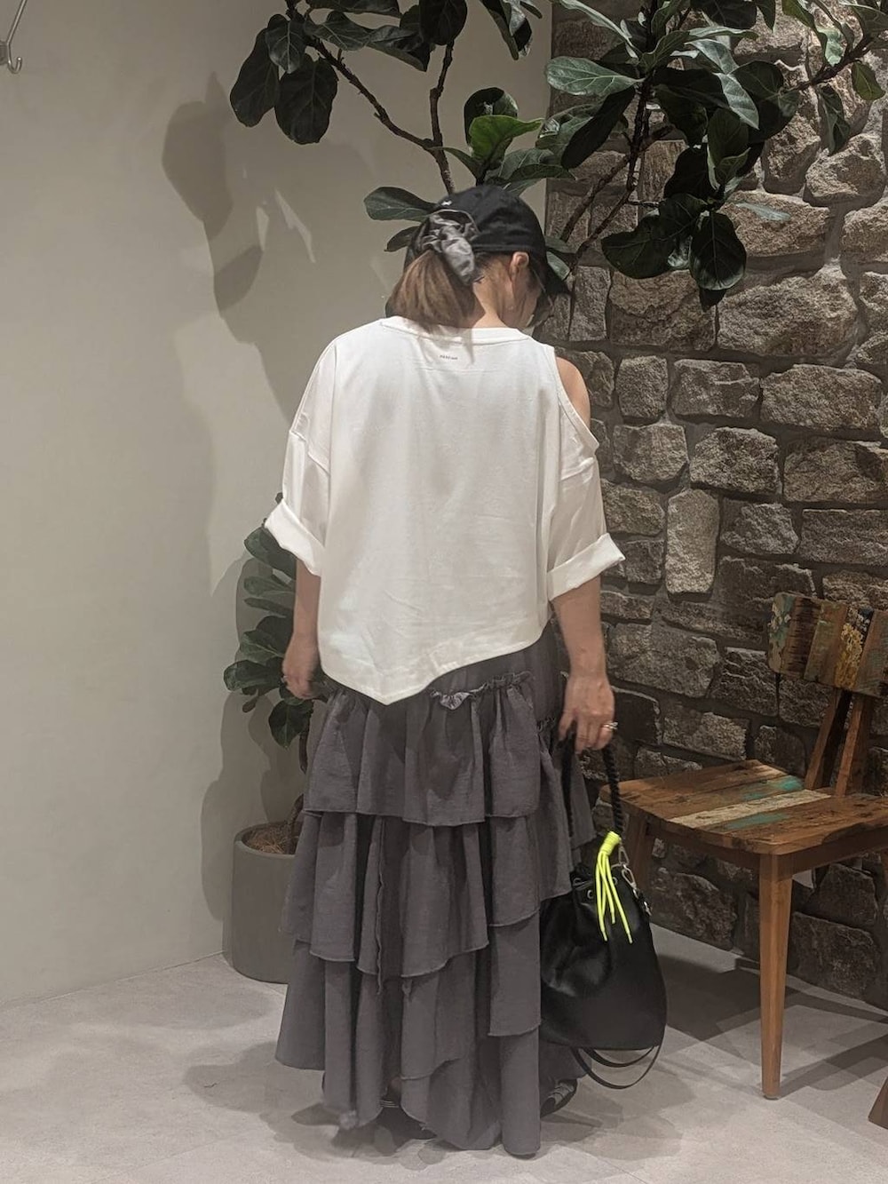 グレー系のワンピース、ブラック系のショルダーバッグ、ブラック系のスニーカーを着用したレディースの夏コーディネートの4枚目の写真
