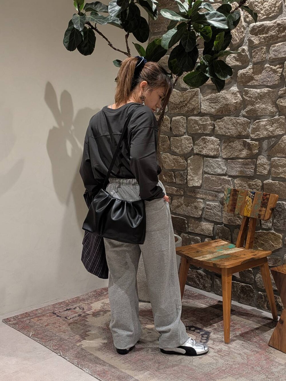 グレー系のスニーカー、グレー系のスウェットパンツ、ブラック系のハンドバッグを着用したレディースの秋コーディネートの4枚目の写真