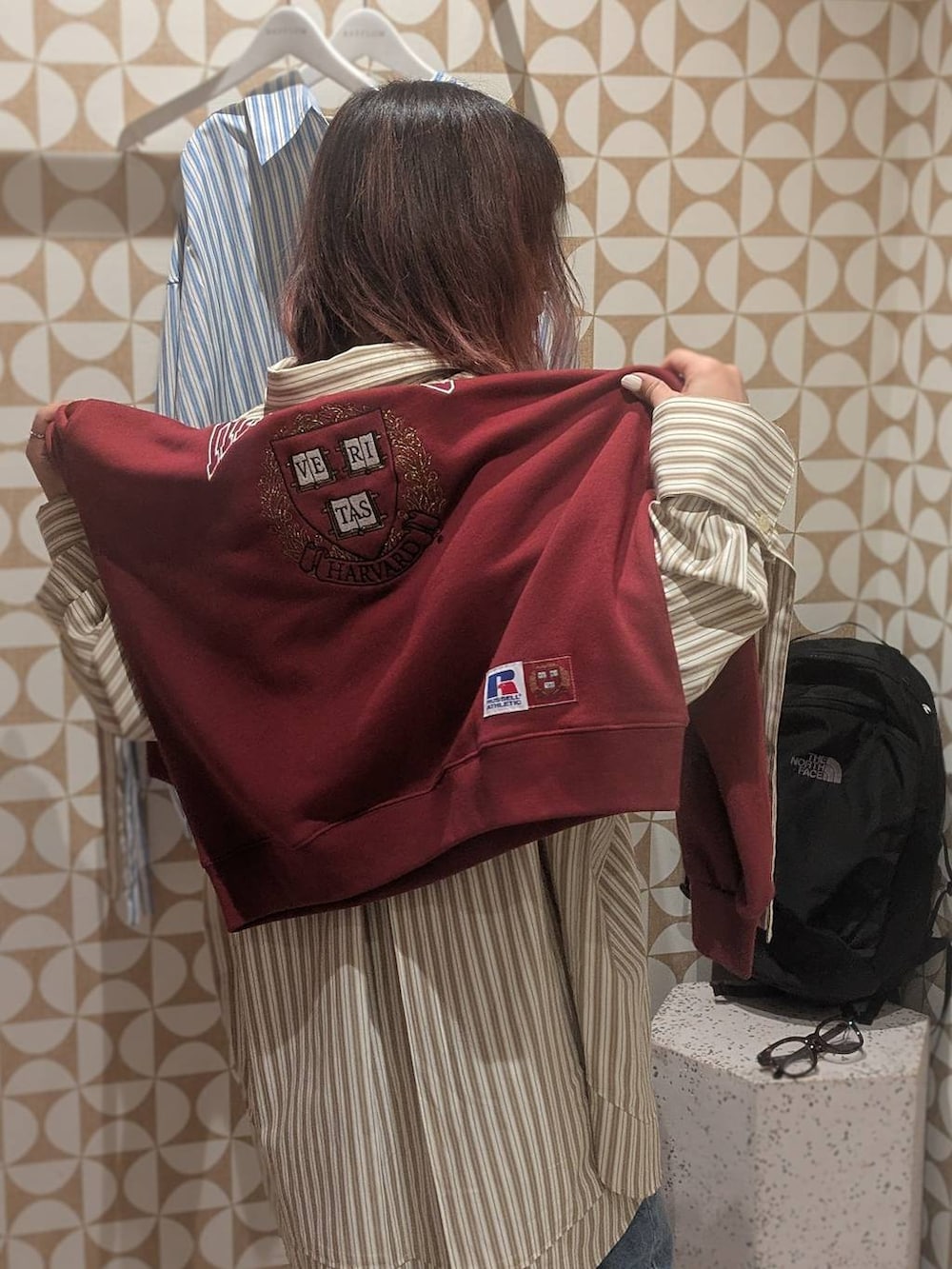 ブラック系のバックパック/リュック、ブルー系のデニムパンツ、レッド系のスウェットを着用したレディースの冬コーディネートの4枚目の写真