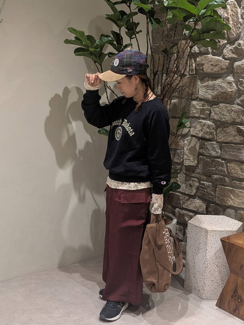 レッド系のスカート、ホワイト系のTシャツ/カットソー、ブルー系のスニーカーを着用したレディースの秋コーディネートの3枚目の写真