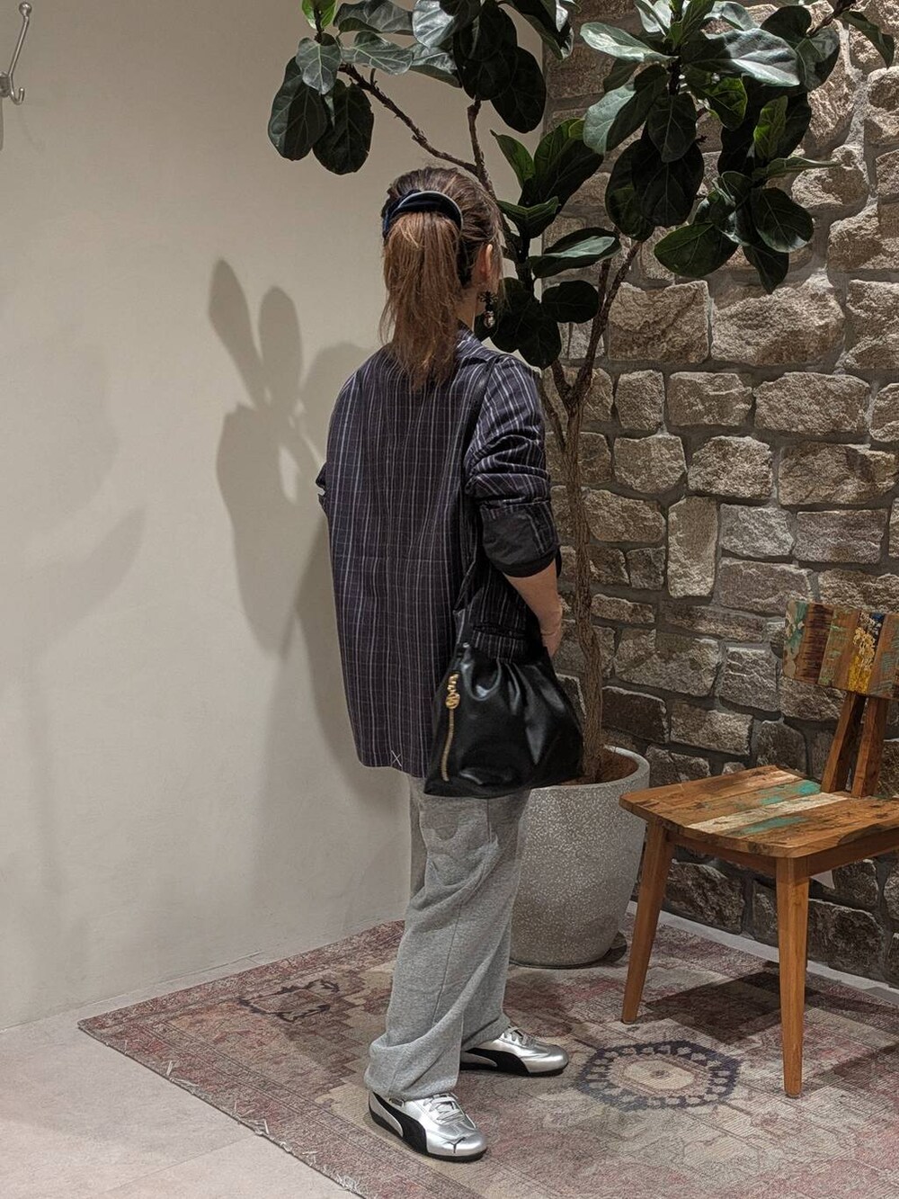 グレー系のスニーカー、グレー系のスウェットパンツ、ブラック系のハンドバッグを着用したレディースの秋コーディネートの2枚目の写真