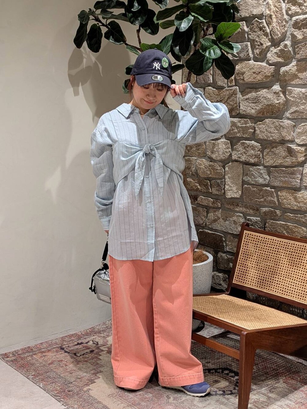 ブルー系のスニーカー、シルバー系のショルダーバッグ、ピンク系のデニムパンツを着用したレディースの冬コーディネートの3枚目の写真