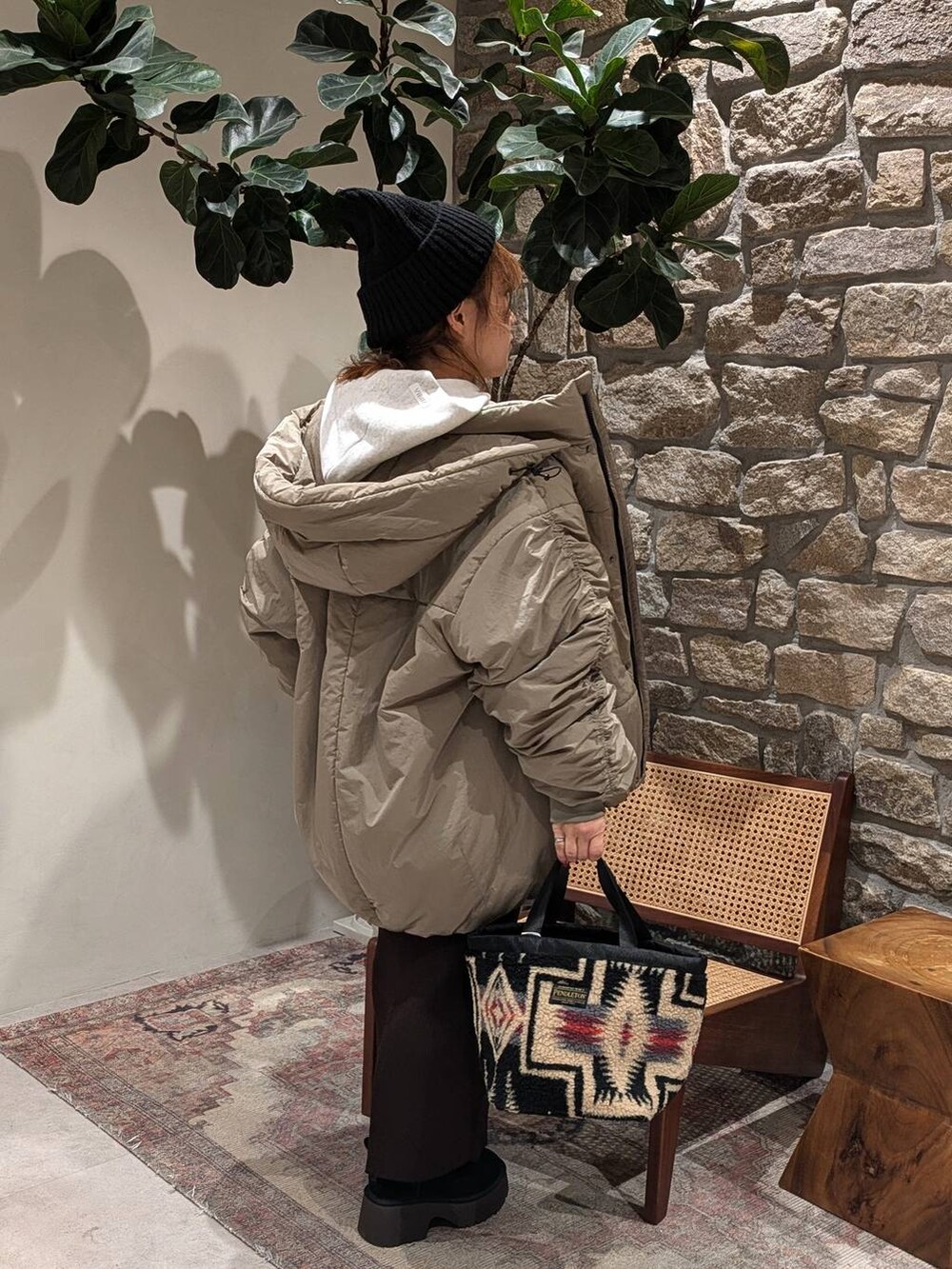 ブラウン系のスカート、グリーン系のブルゾン、グレー系のパーカーを着用したレディースの秋コーディネートの2枚目の写真