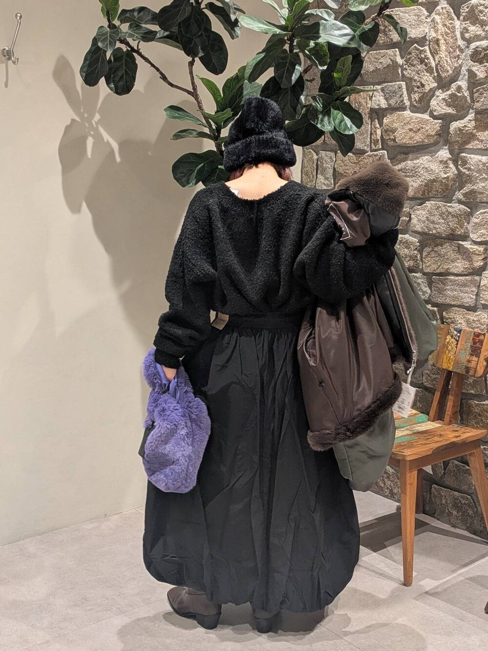 ブラウン系のブーツ、ブラウン系のブルゾン、パープル系のハンドバッグを着用したレディースの秋コーディネートの4枚目の写真