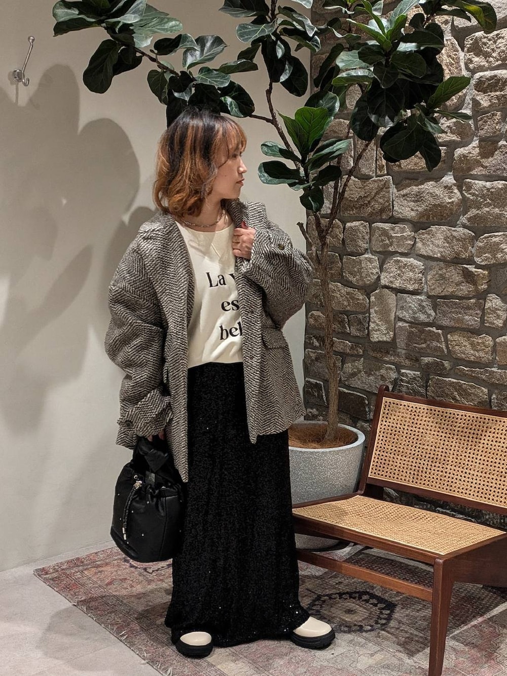 ホワイト系のブーツ、ブラウン系のその他アウター、ブラック系のスカートを着用したレディースの秋コーディネートの2枚目の写真