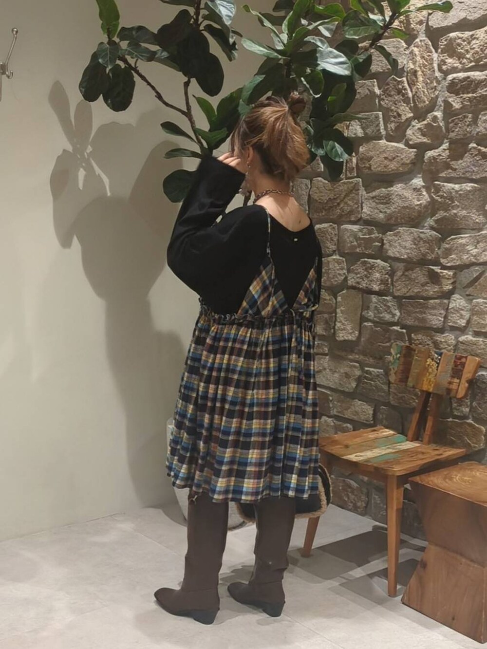 ブラウン系のブーツ、ブラック系のハンドバッグ、グレー系のネックレスを着用したレディースの秋コーディネートの3枚目の写真