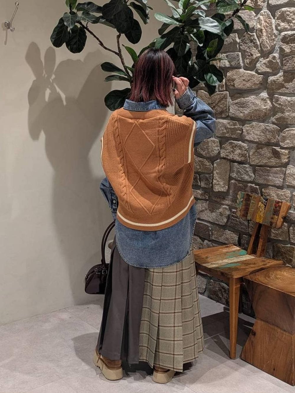 イエロー系のベスト、ブルー系のシャツ/ブラウス、ベージュ系のスカートを着用したレディースの冬コーディネートの3枚目の写真