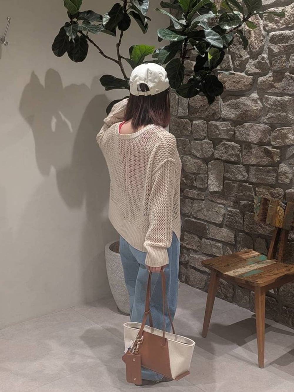 レッド系のタンクトップ、ブラウン系のハンドバッグ、ブラウン系のパンプスを着用したレディースの春コーディネートの2枚目の写真