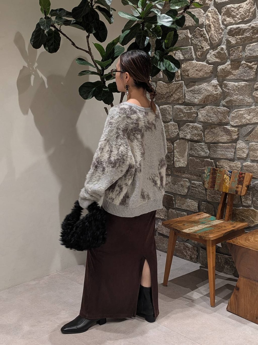 ブラウン系のスカート、ブラック系のブーツ、グレー系のニット/セーターを着用したレディースの秋コーディネートの2枚目の写真
