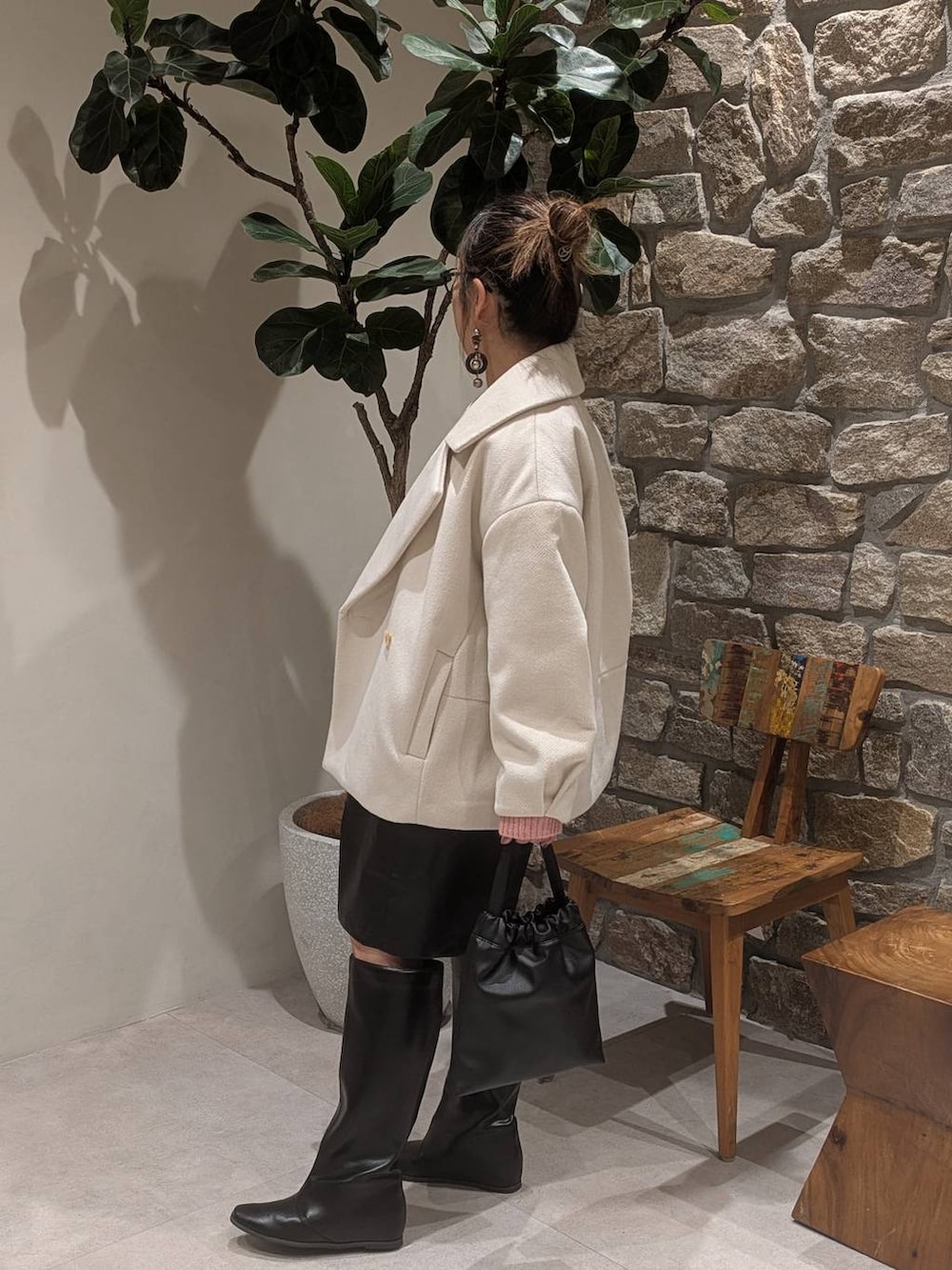 ブラック系のブーツ、ブラック系のハンドバッグを着用したレディースの秋コーディネートの4枚目の写真