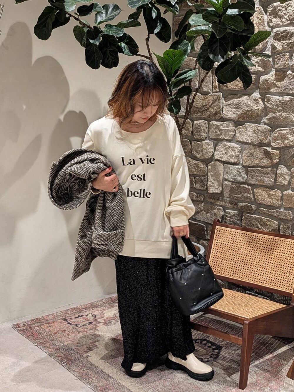 ホワイト系のブーツ、ブラウン系のその他アウター、ブラック系のスカートを着用したレディースの秋コーディネートの4枚目の写真