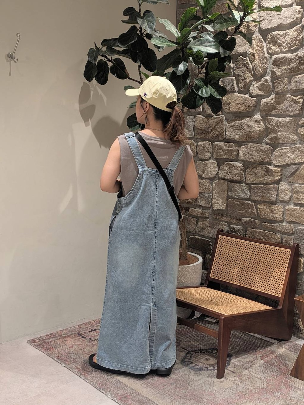 ブラック系のサンダル、ブルー系のジャンパースカート、ブラウン系のTシャツ/カットソーを着用したレディースの夏コーディネートの3枚目の写真