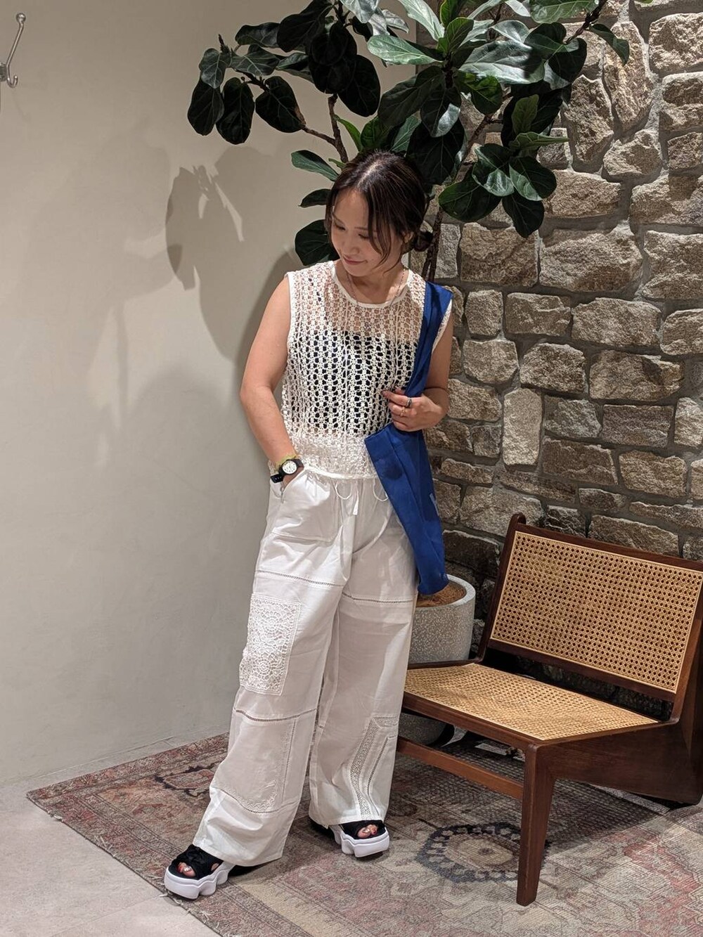 ブルー系のエコバッグ/サブバッグ、ホワイト系のベスト、ホワイト系のその他パンツを着用したレディースの夏コーディネートの3枚目の写真