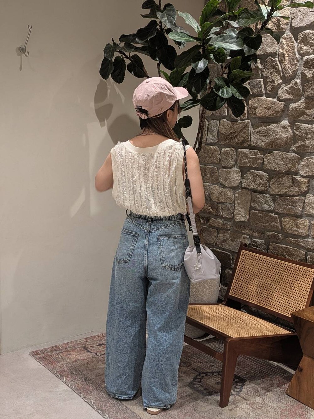 ブルー系のデニムパンツ、グレー系のショルダーバッグ、ホワイト系のサンダルを着用したレディースの夏コーディネートの4枚目の写真