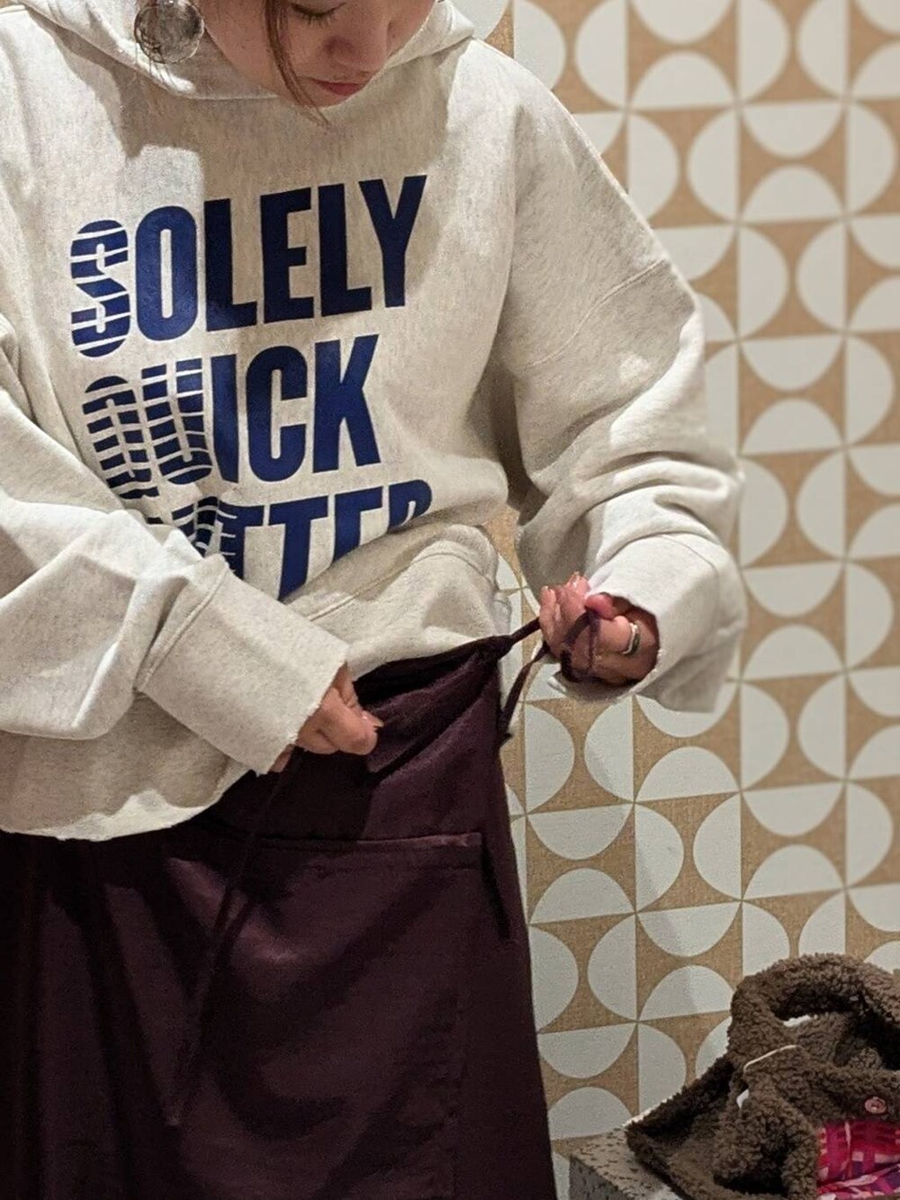 ブラウン系のトートバッグ、グレー系のパーカー、ベージュ系のパーカーを着用したレディースの秋コーディネートの2枚目の写真