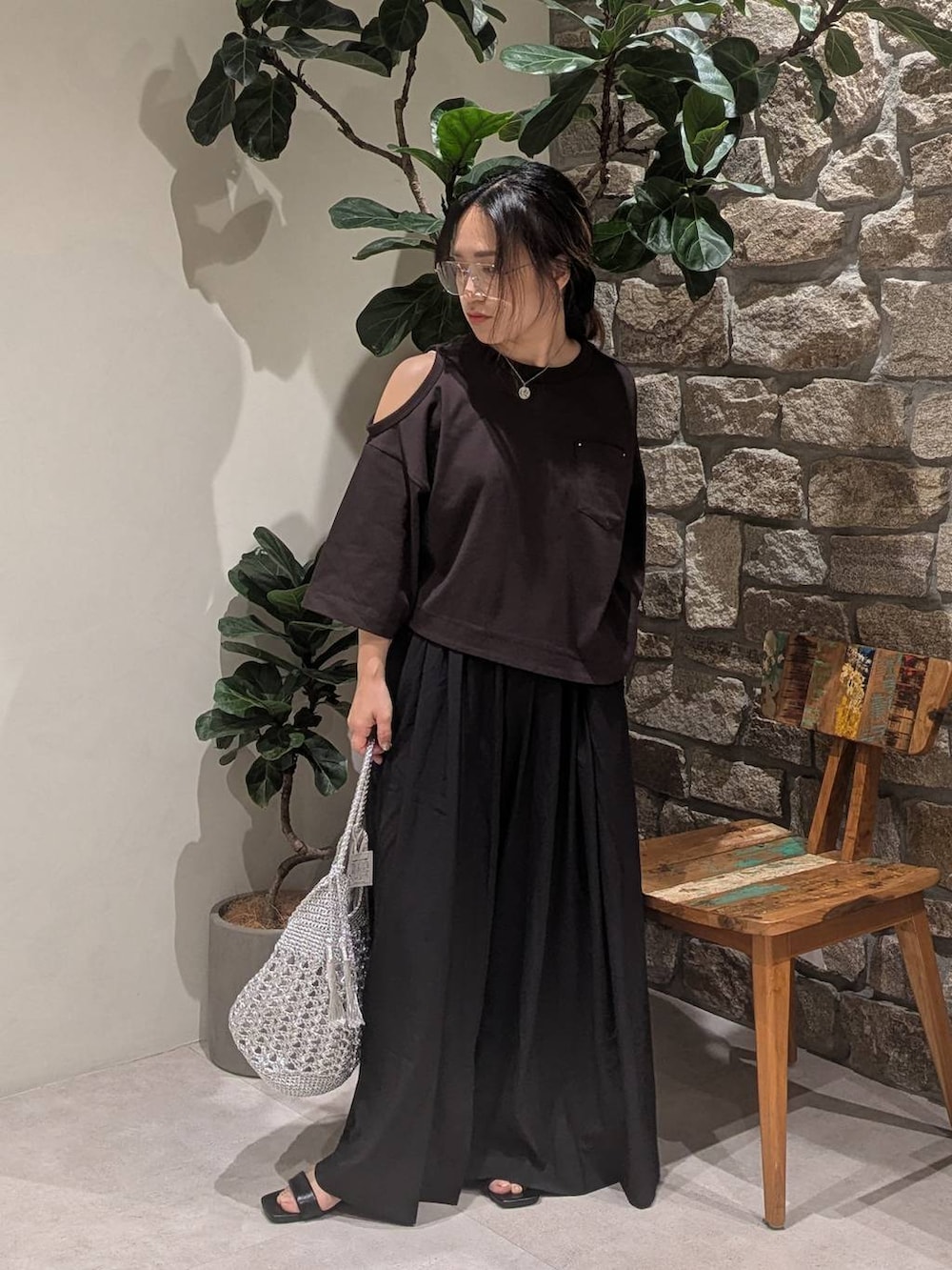 ブラック系のサンダル、ブラウン系のTシャツ/カットソー、シルバー系のショルダーバッグを着用したレディースの夏コーディネートの2枚目の写真