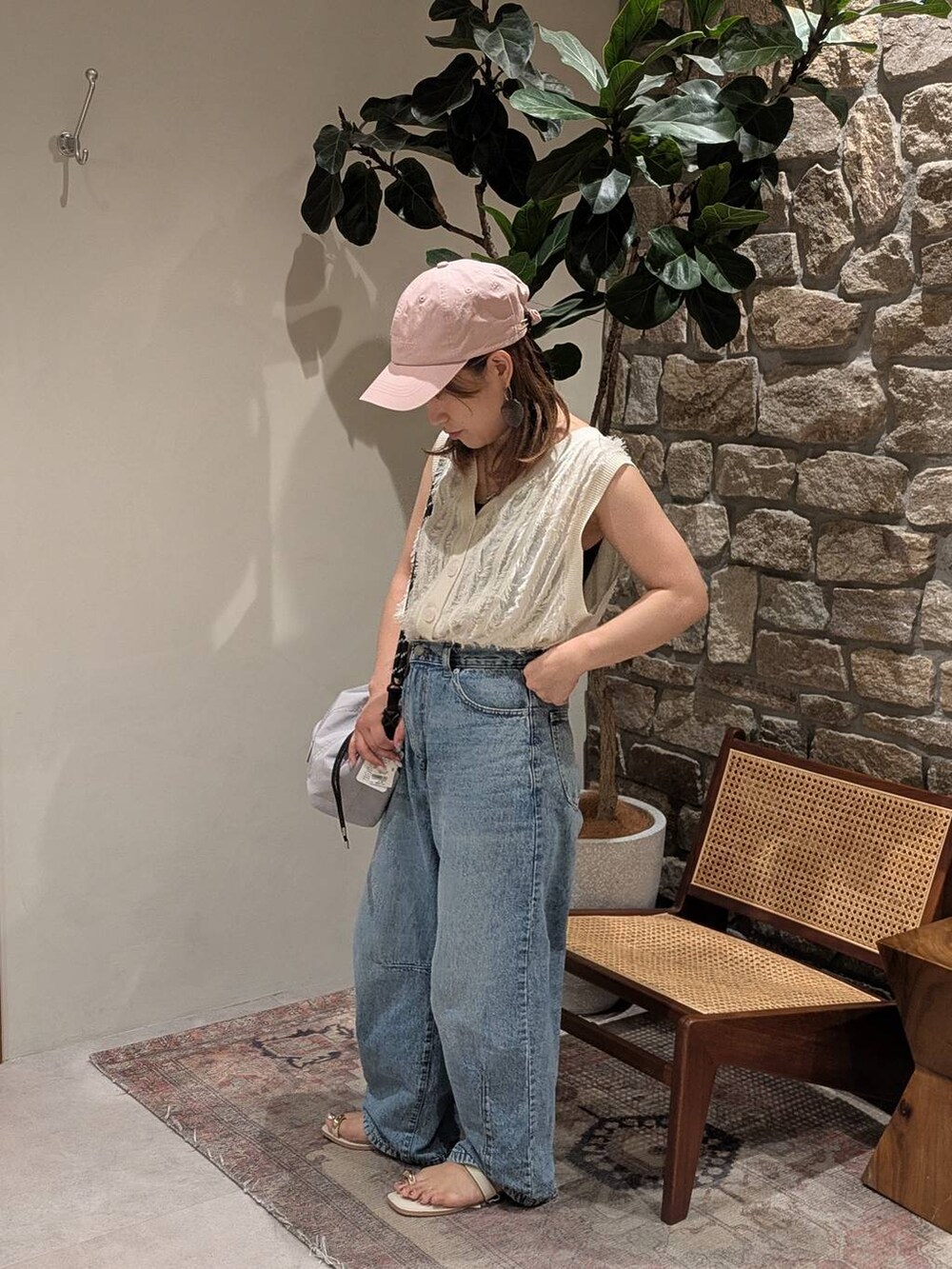 ブルー系のデニムパンツ、グレー系のショルダーバッグ、ホワイト系のサンダルを着用したレディースの夏コーディネートの2枚目の写真