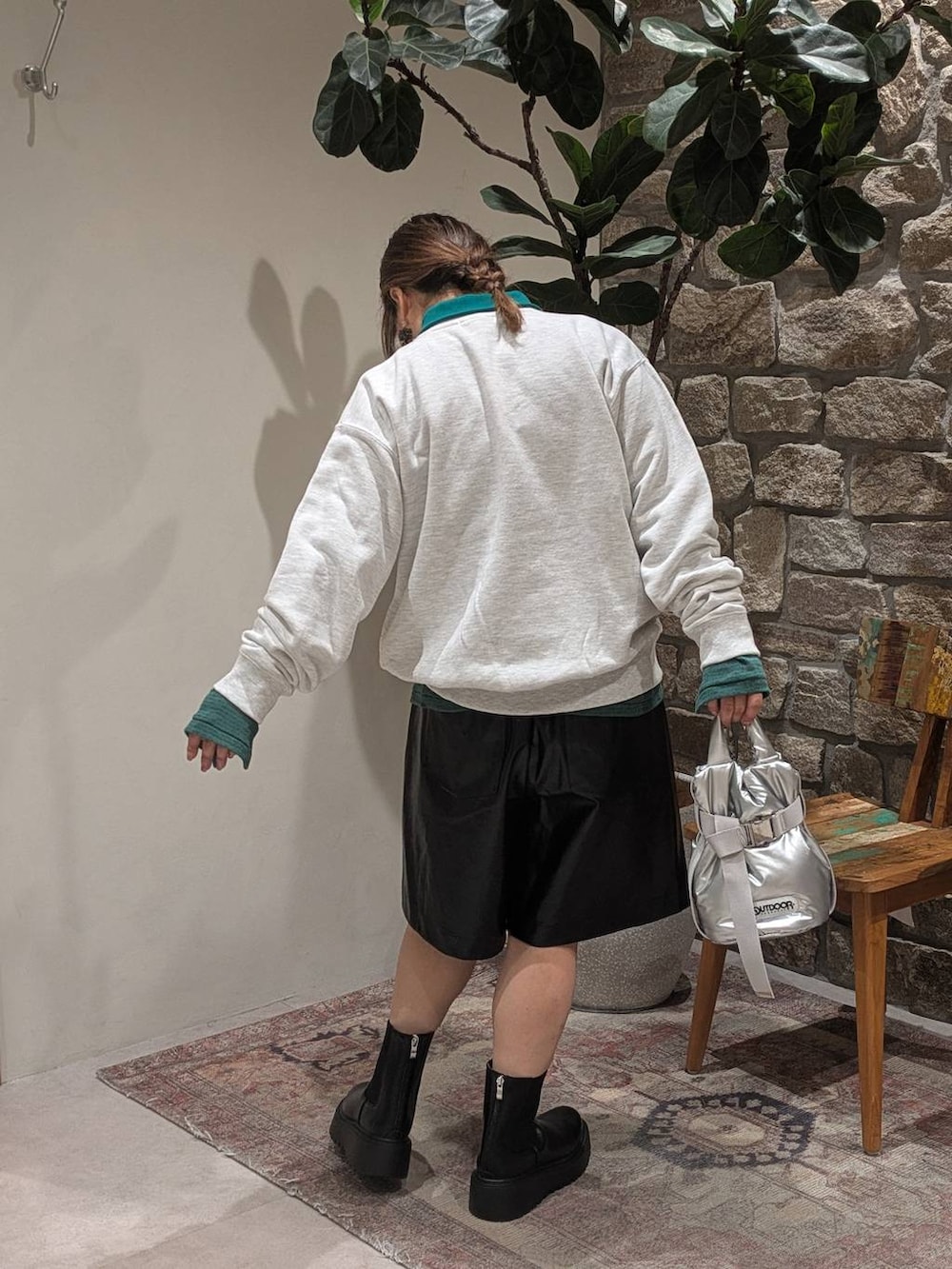 グリーン系のTシャツ/カットソー、ベージュ系のスウェット、ブラック系のブーツを着用したレディースの秋コーディネートの6枚目の写真