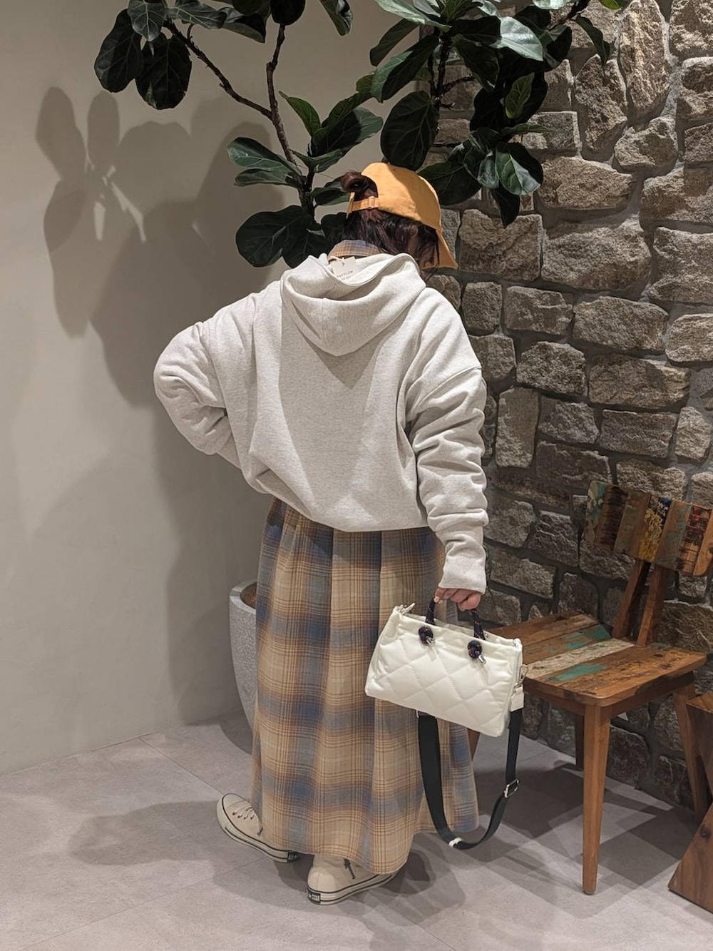 ホワイト系のスニーカー、イエロー系のシャツワンピース、ホワイト系のショルダーバッグを着用したレディースの冬コーディネートの3枚目の写真