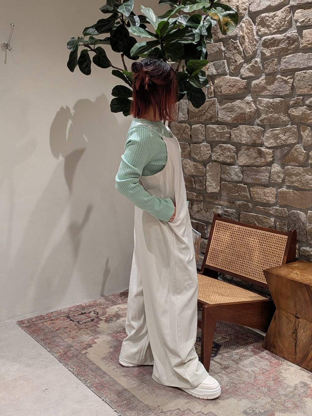 ホワイト系のスニーカー、グリーン系のニット/セーター、ベージュ系のつなぎ/オールインワンを着用したレディースの冬コーディネートの2枚目の写真