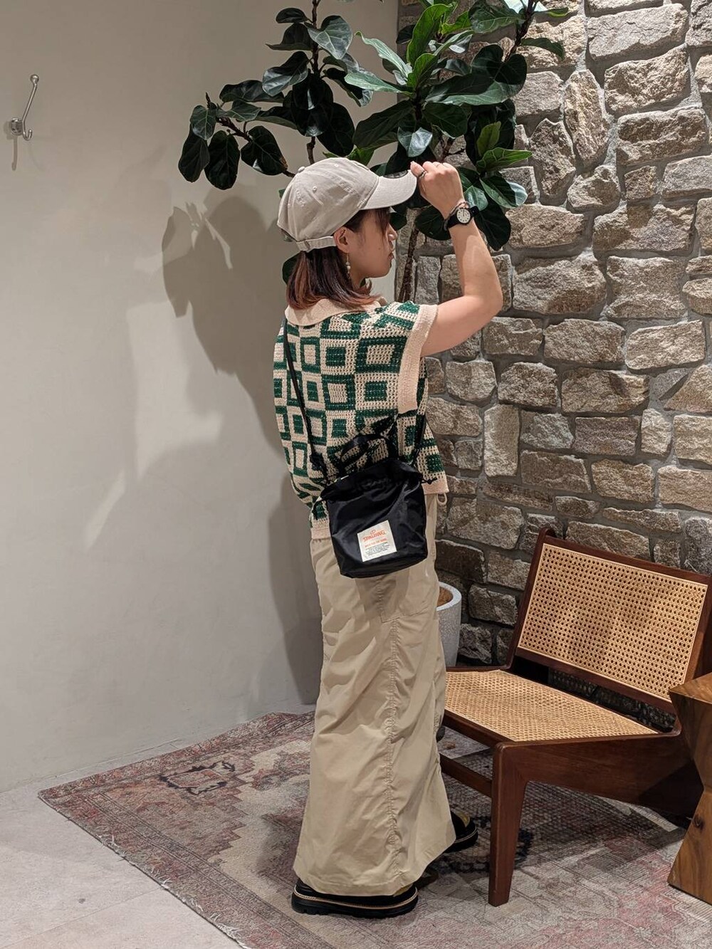 ブラウン系のサンダル、ブラック系のショルダーバッグ、ベージュ系のスカートを着用したレディースの春コーディネートの2枚目の写真