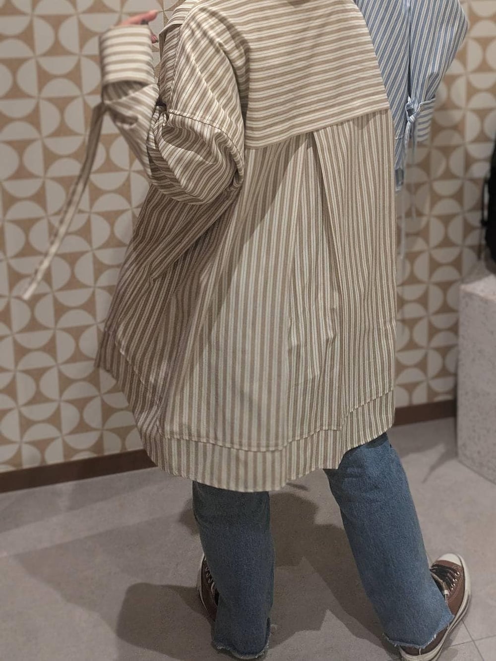 ブラック系のバックパック/リュック、ブルー系のデニムパンツ、レッド系のスウェットを着用したレディースの冬コーディネートの3枚目の写真